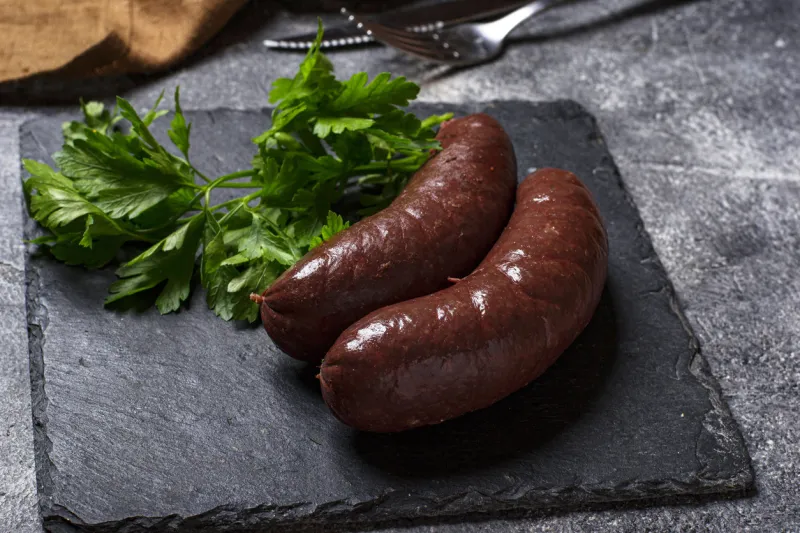 homemade uncooked black pudding sausages on cutting board