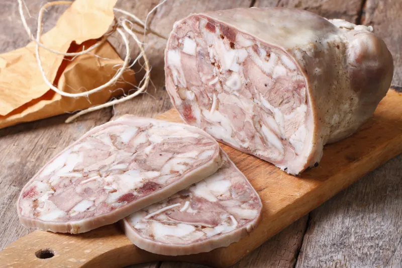 cut headcheese on chopping board close-up horizontal