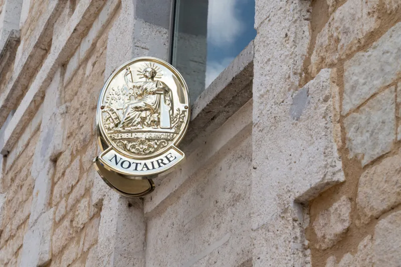 french notaire sign on wall above entrance to the notary office