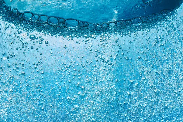 sparkling mineral water background blue bubbles of fresh soda float to the surface of drink to quench your thirst