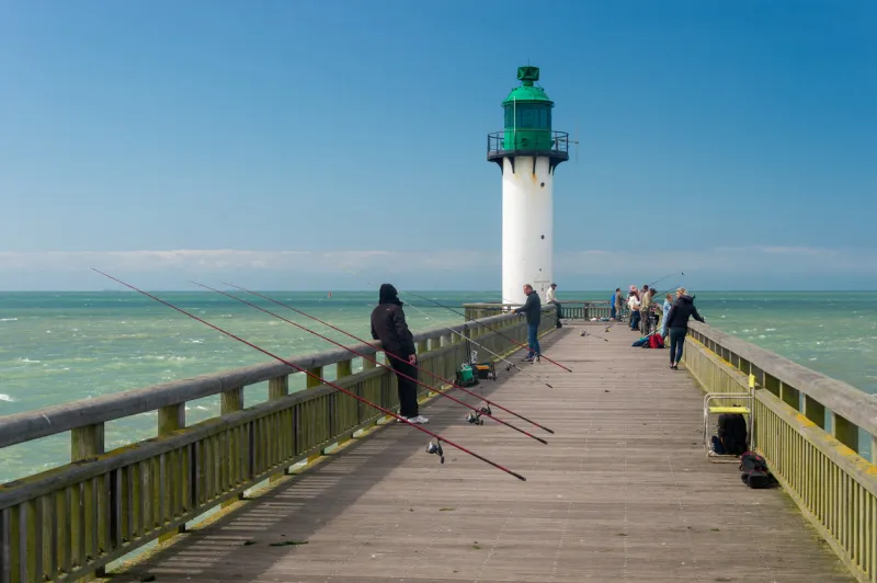 calais, france - 19 june 2018  fishermen on the west jetty in the summertime