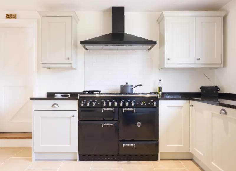 modern modular kitchen interior in black and off white, with range cooker and chimney extractor hood uk painted wood farmhouse kitchen design