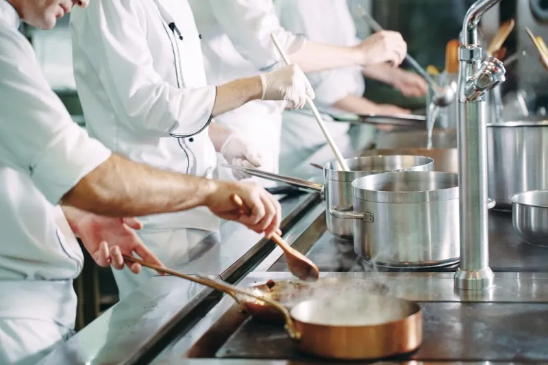 chef cooking vegetables in wok pan shallow dof