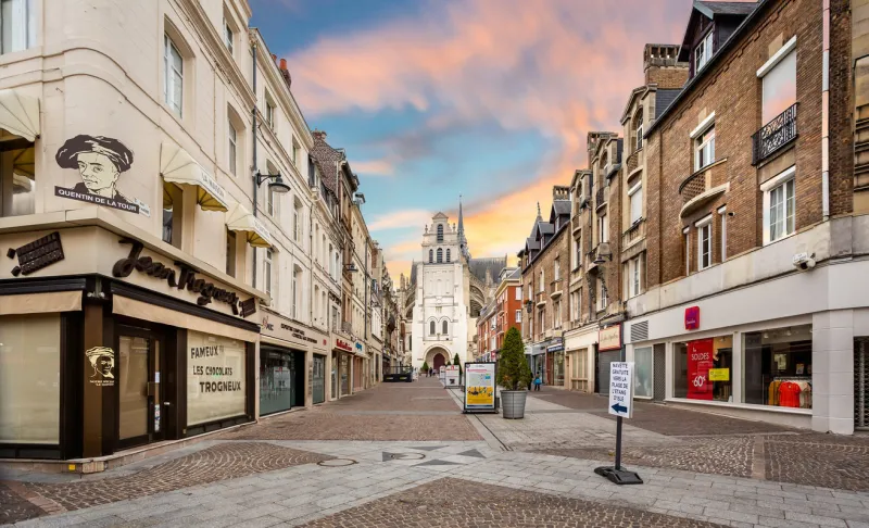 shopping precinct leading to the basilica of saint quentin at sunset (church) in saint quentin, aisne, france on 7 july