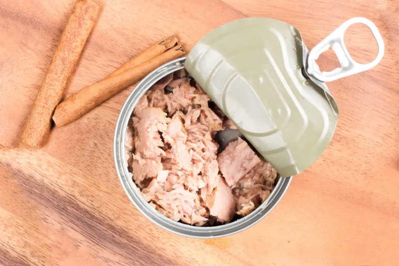 tuna in can on wood plate on wooden background tuna fish food top view