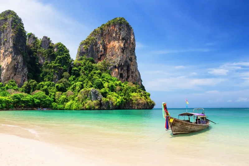 thai traditional wooden longtail boat and beautiful sand railay beach in krabi province ao nang, thailand