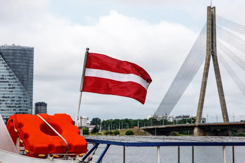 flag of the republic of latvia cable-stayed bridge in riga on the background