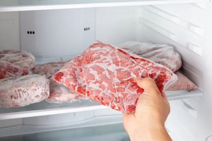 man taking out frozen meat from freezer frozen food