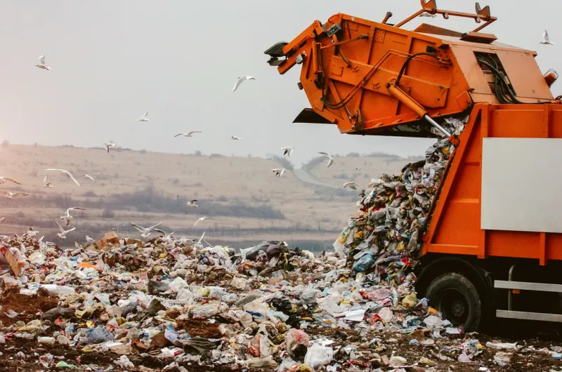 garbage truck dumping the garbage on a landfill