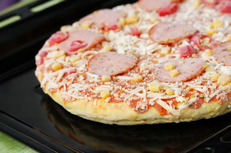 frozen pizza with salami, cheese, corn and pepper