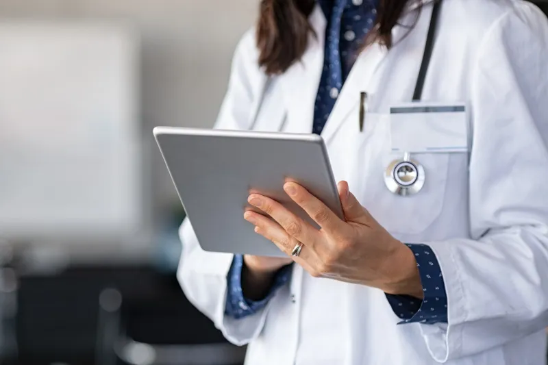 close up of woman doctor hands using digital tablet at clinic closeup of female doctor in labcoat and stethoscope holding digital tablet, reading patient report hands holding medical report, copy space