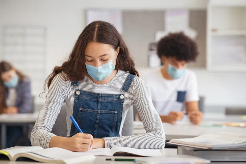 high school girl studying in class with face mask