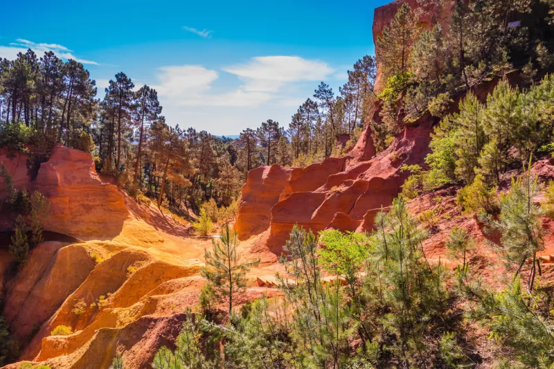 scenic pit mining ocher - natural dyes roussillon, provence red villagemulti-colored outcrops - from yellow to red-orange green trees create beautiful contrast from ochre roussillon, red village of provence