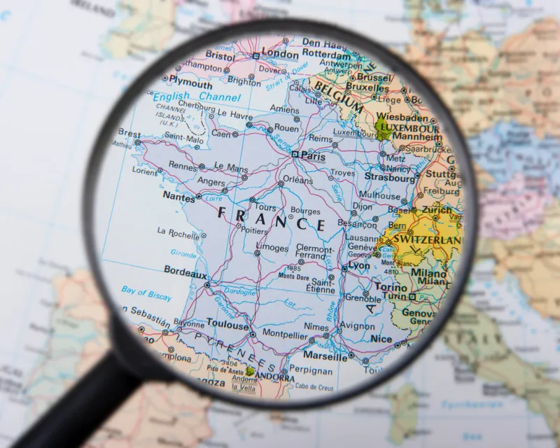 a magnifying glass over a map focusing on france