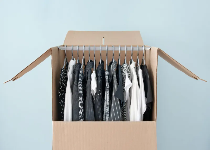 black and white clothes hanging in a wardrobe box, prepared for moving