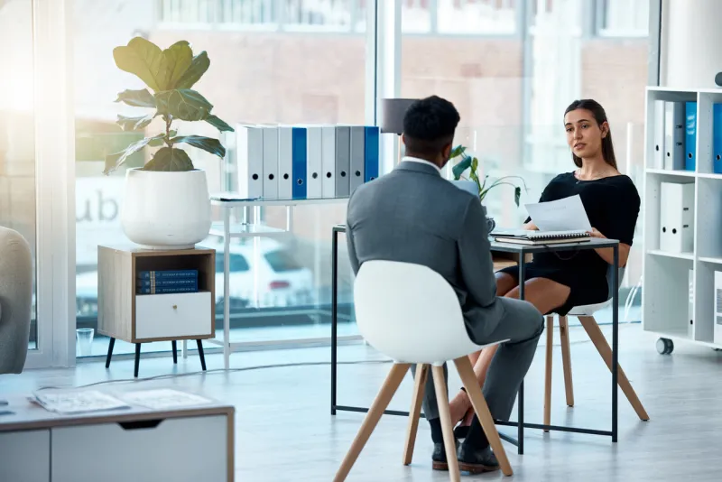 shot of a young businesswoman going through a resume from an applicant during a job interview in an office