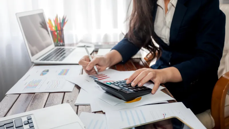 businesswoman working finance with calculator in office