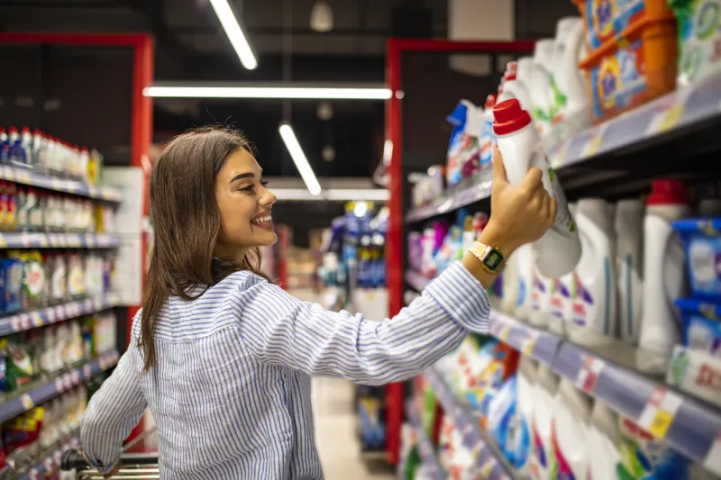 pretty young woman buying groceries in a supermarket mall grocery store beautiful brunette looking at some shelves in a supermarket trying to decide what to buy