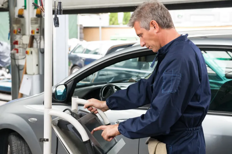 portrait of mature car mechanic working at service station