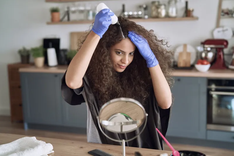 beautiful woman coloring her hair at home