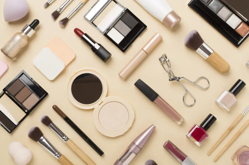 flat lay with makeup products and tools on color background