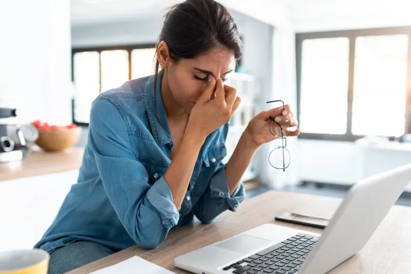 shot of stressed business woman working from home on laptop looking worried, tired and overwhelmed