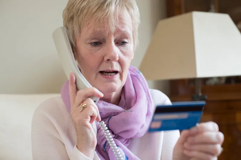 senior woman giving credit card details on the phone