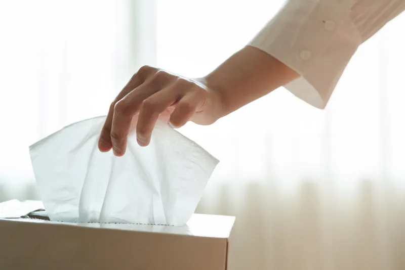 women hand picking napkin tissue paper from the tissue box