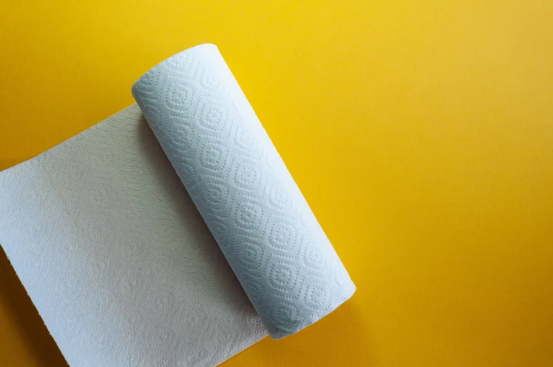 paper towel roll on the bushing on yellow background kitchen paper on a table indoors