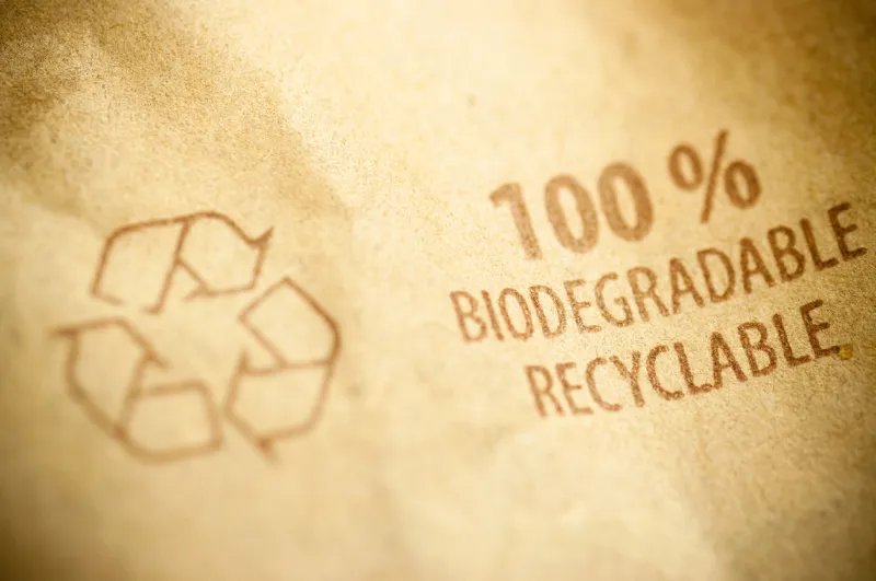 words 100 biodegradable ans recyclable written on a kraft recycled paper with arrow sign