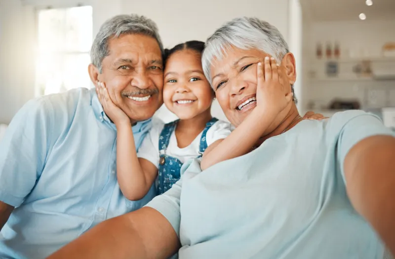 shot of grandparents bonding with their granddaughter on a sofa at home
