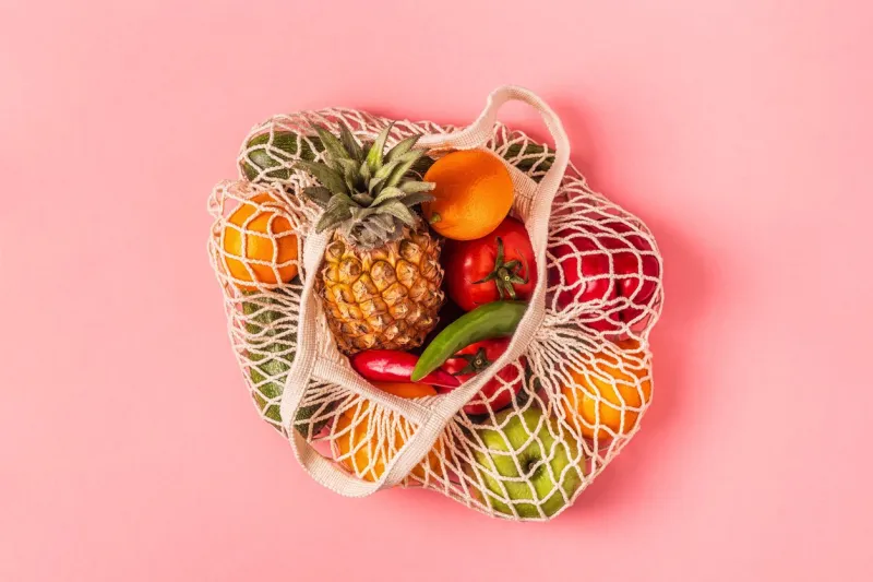 fresh vegetables and fruits in bag mesh, top view