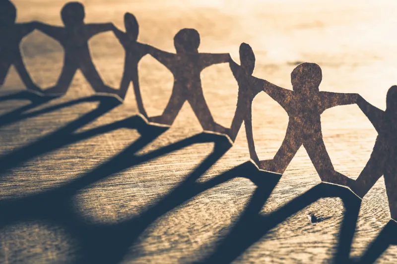 human chain paper with light and shadow on wood table