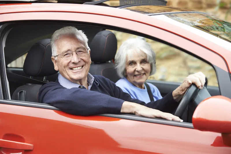 portrait of smiling senior couple out for drive in car