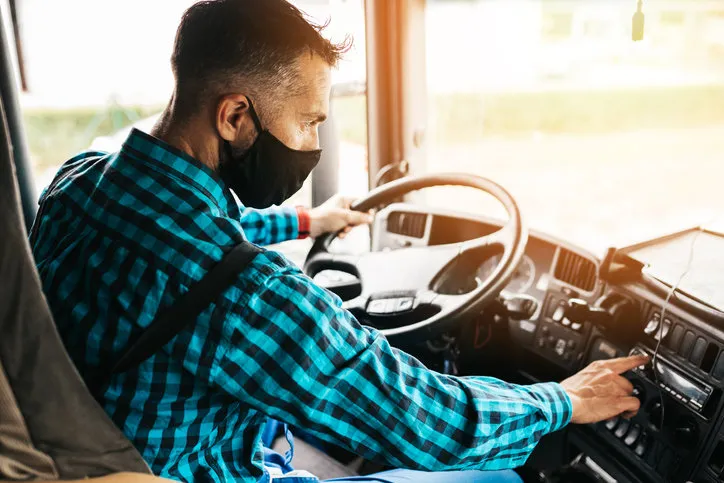 young handsome male with face protective mask driving his truck