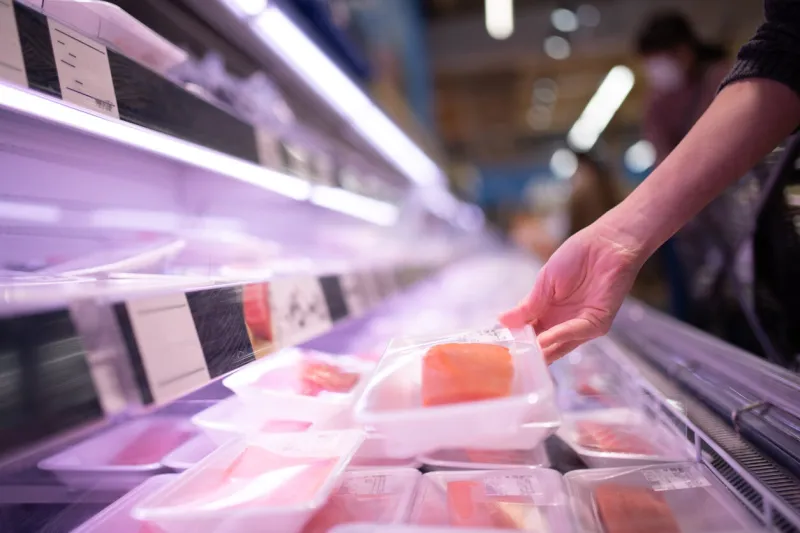 woman buying fish fillet in supermarket