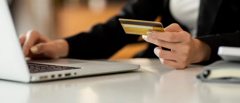 close up woman hand using credit card and smartphone laptop for buying online shopping