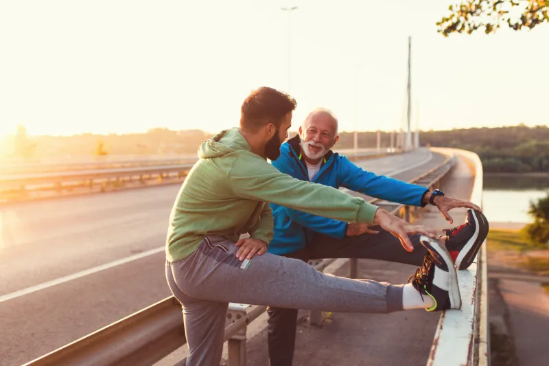 happy father and son exercising together outdoors on big modern bridge