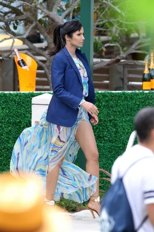 padma lakshmi wearing a pretty blue cover-up and high heels as she walks poolside in miami