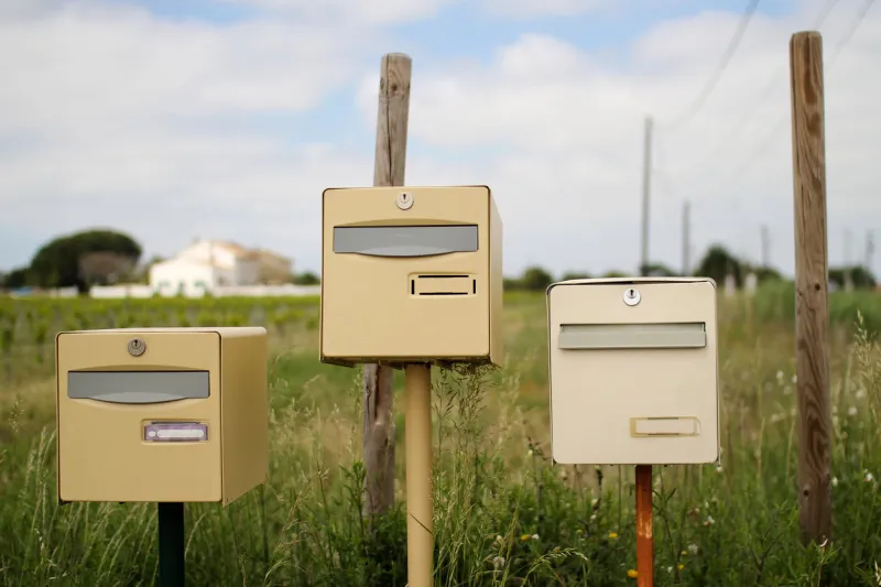 beige mailboxes with house in the background taken in provence