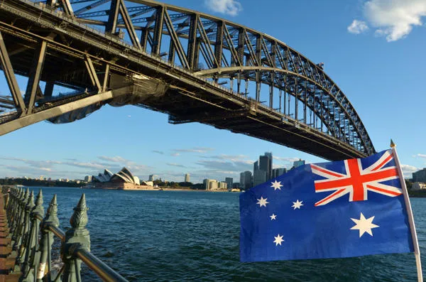 le drapeau national de l'australie vole sous sydney harbour bridge et l'opéra à sydney, australie