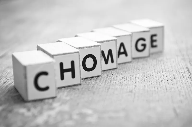 concept word forming with cube on wooden desk background - chomage (unemployment in french)