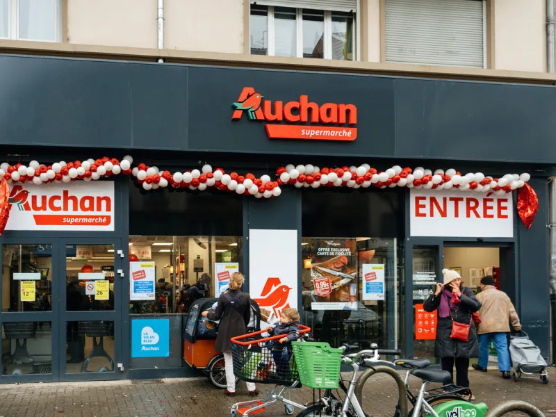 strasbourg  new auchan supermarket entrance in french neighborhood on a winter snow day with customers exiting the entrance of the store