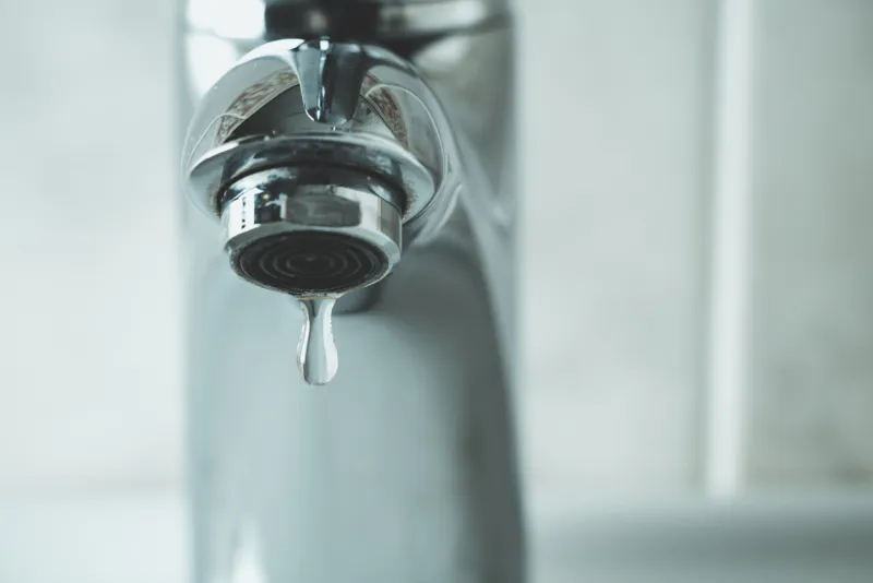 water drop dripping from the tap and water shortage