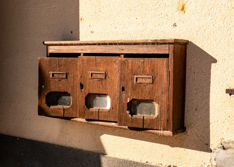 mailboxes on a wall in the sun