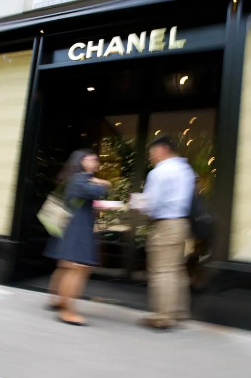 les gens se tiennent devant la vitrine d'un magasin de mode chanel, le 26 avril 2013 à la place vendome à paris photo afp lionel bonaventure afp photo lionel bonaventure