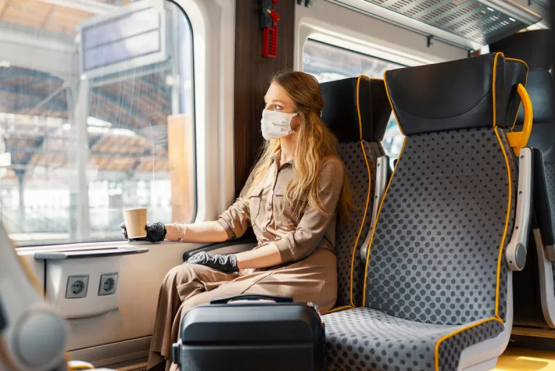 woman wearing white protective face mask is using public transpo