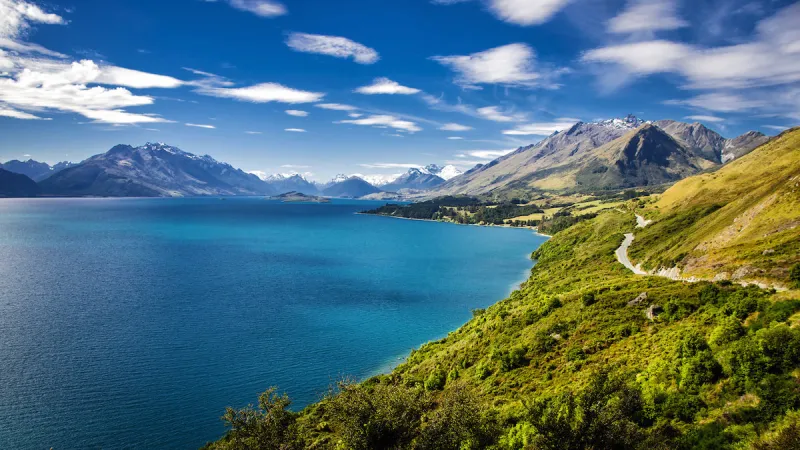 summer view of lake wakatipu and the road from queenstown to glenorchy southern alps mountains in the distance