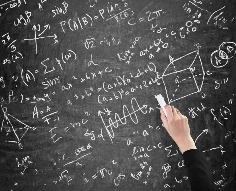 la main d'une femme écrit des calculs de maths sur l'analyste de tableau noir