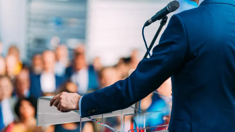 politician during election campaign, speaking to the crowd from stage